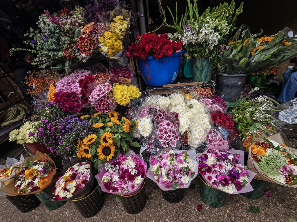 An array of bouquets of different flower arrangements lined up in a stall
